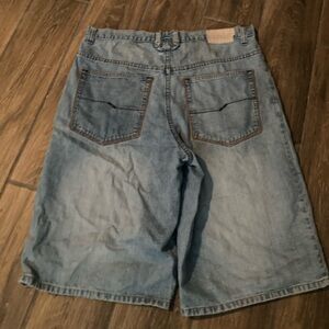 Baggy blue denim shorts with brown stitching